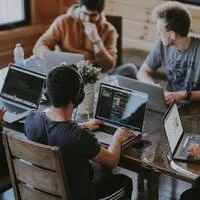 A small dev team working on laptops around a table